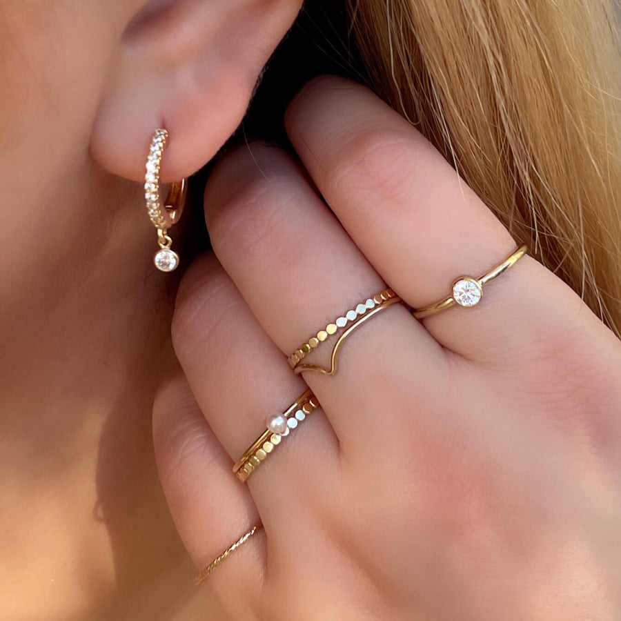 Close Up Of Model Wearing Ale Weston Stacker Rings with with Sparkle cz huggie hoop earrings