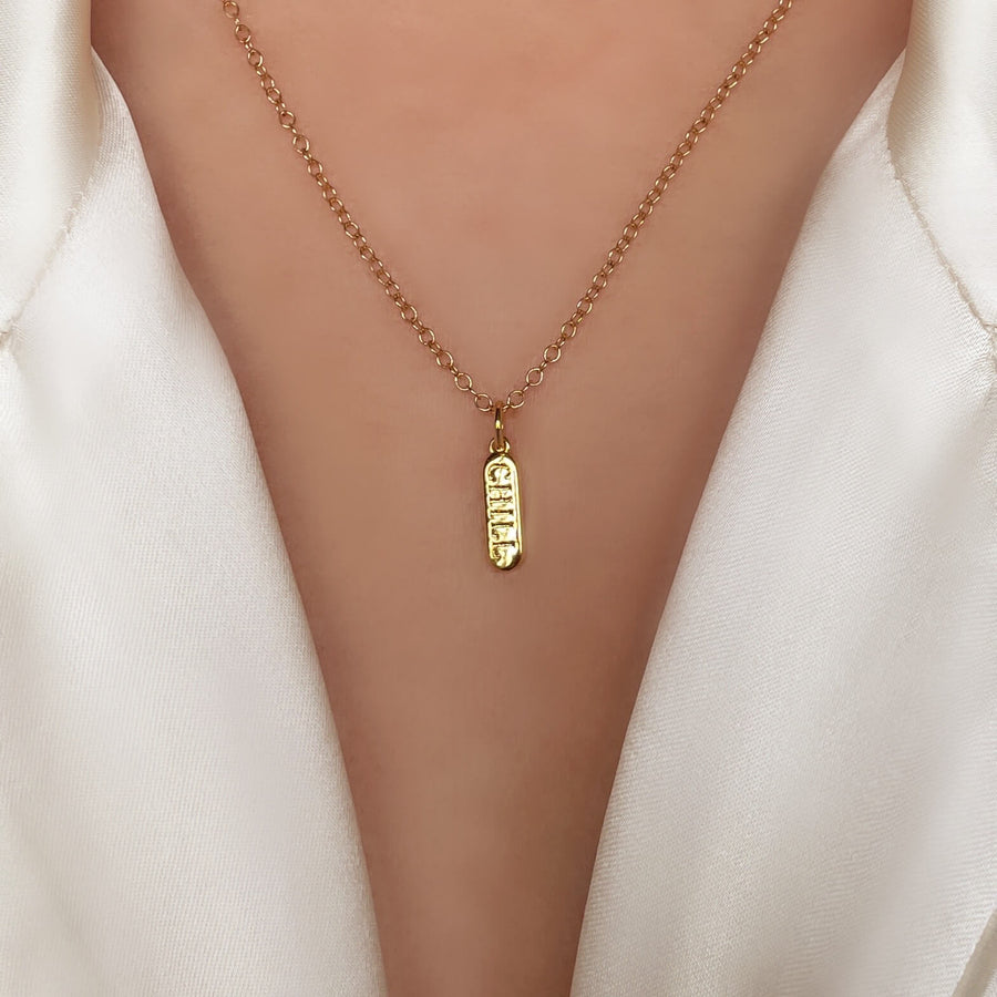 Model-Wearing-Gold-Chill-Pill-Charm-with-cable-chain-necklace